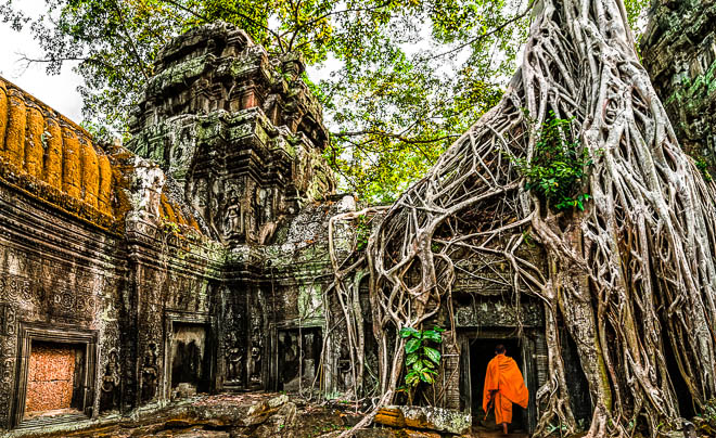 Un monaco tra le rovine del tempio di Ta Prohm in Cambogia
